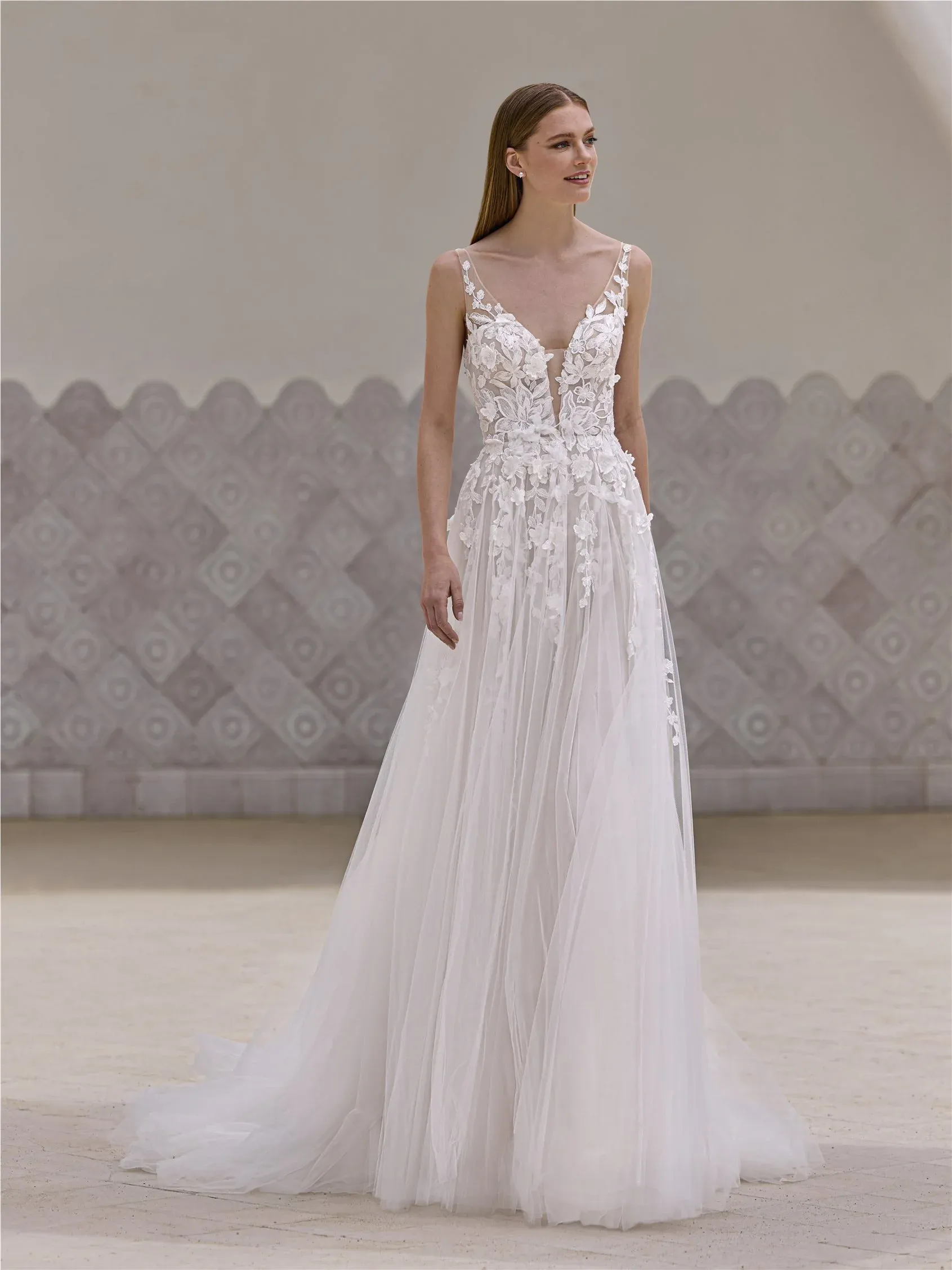 Robe de mariée Yeoh de Pronovias. Une coupe A-line en tulle et dentelle avec un décolleté en V, une taille cintrée et une traîne de 180 cm