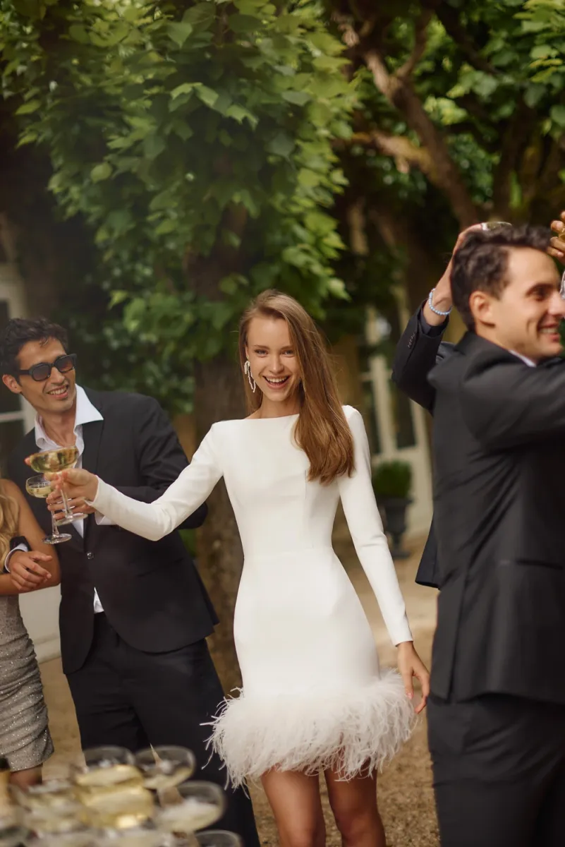 Robe de mariage  courte de cérémonie de mariage ourlet à plumes manches longues coachella 2026 eva lendel marseilleRobe de mariage  courte de cérémonie de mariage ourlet à plumes manches longues coachella eva lendel marseille