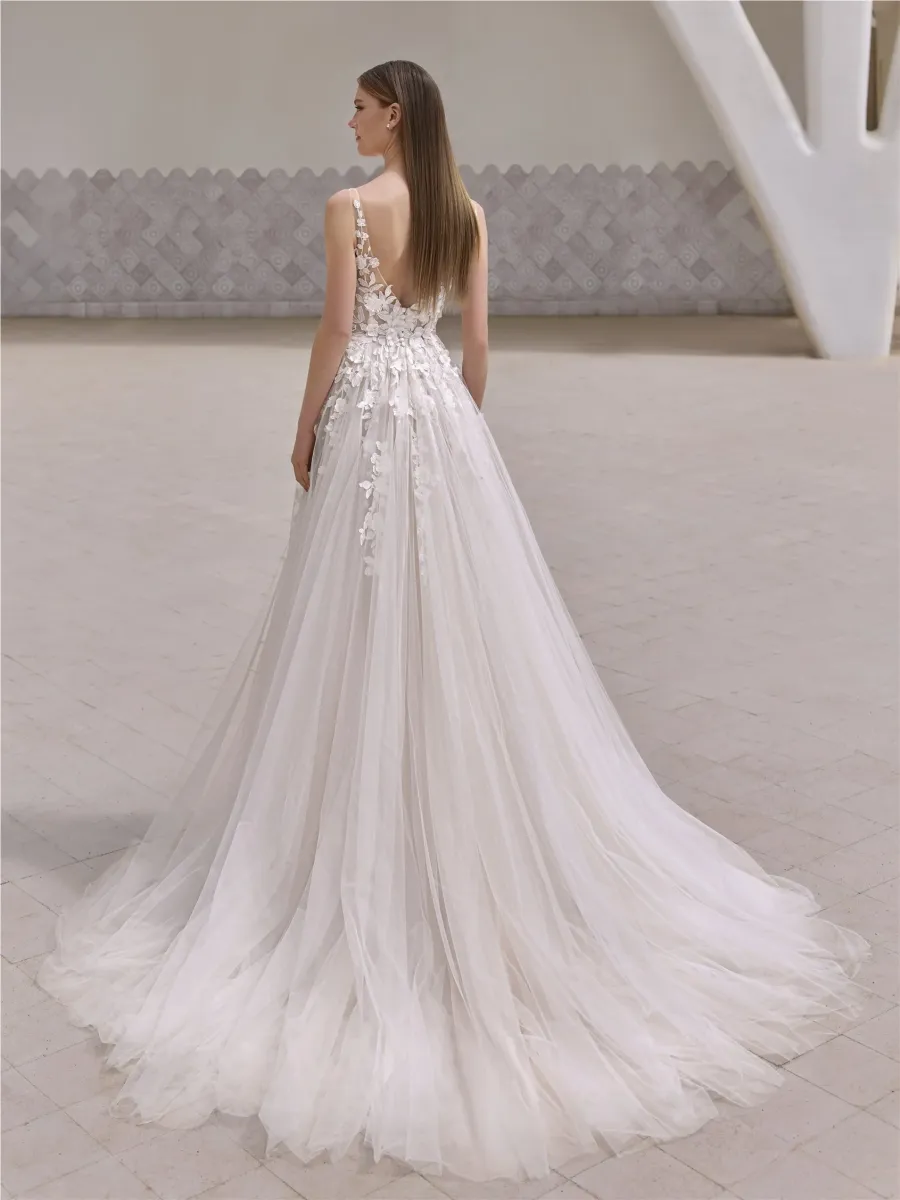 Robe de mariée princesse en mikado blanc, avec un décolleté cœur structuré, et une longue traîne majestueuse.